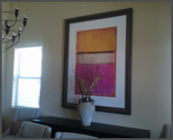 oversize framed art hanging in dining area